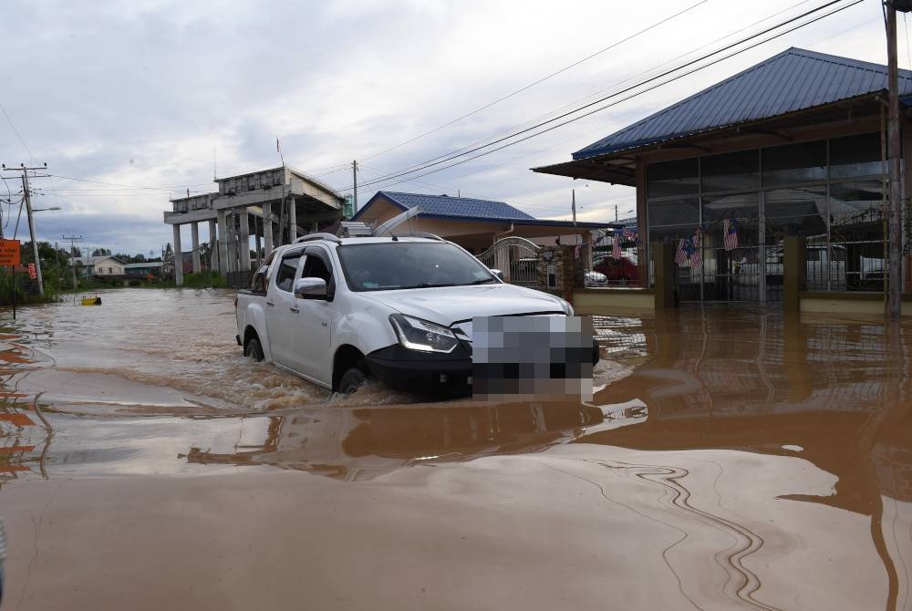 Sebuah kenderaan meredah Jalan Ketiau Putatan yang ditenggelami banjir susulan hujan lebat berterusan di sekitar Bandaraya Kota Kinabalu petang kelmarin. Foto Bernama