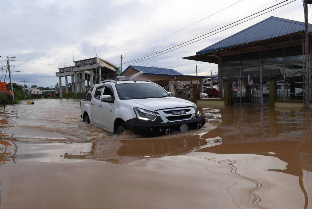 Sebuah kenderaan meredah Jalan Ketiau Putatan yang ditenggelami banjir pada Isnin susulan hujan lebat berterusan di sekitar Bandaraya Kota Kinabalu pada petang Sabtu. - Foto Bernama