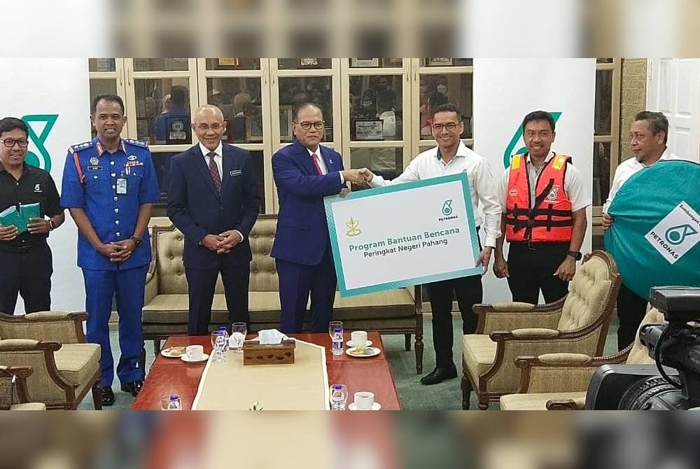 Mohammad Ahmad Shazly (tiga dari kanan) menyerahkan sumbangan persiapan banjir Petronas kepada Wan Rosdy di Wisma Sri Pahang pada Khamis.