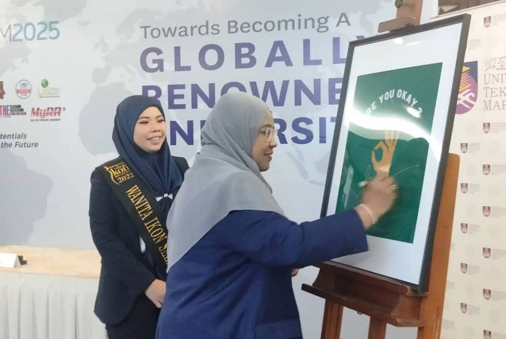 Roziah diiringi Rita Sosilawati menandatangani poster &#039;Are You Ok Centre&#039; di UiTM Shah Alam pada Khamis.