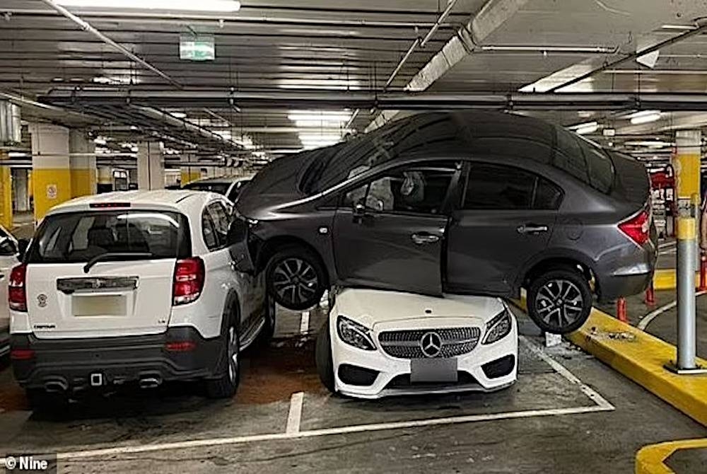 Sebuah kereta Honda berada di atas bumbung sebuah kereta Mercedes di tempat meletak kenderaan di sebuah pusat beli-belah di Sydney pada Khamis. - Foto Nine