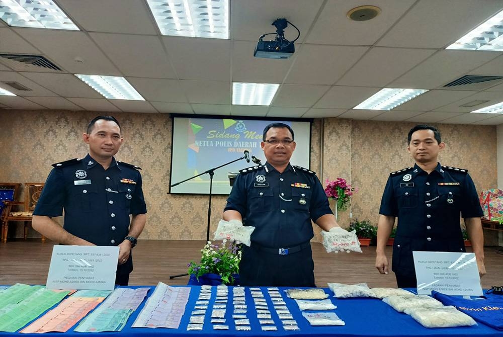 Razlam (tengah) bersama hasil rampasan dadah dalam serbuan di sebuah rumah di Matang pada Khamis.