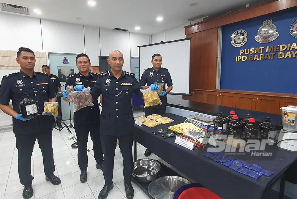 Soffian (kanan) bersama pegawai penyiasat menunjukkan dadah yang dirampas daripada pasangan suami isteri pada Selasa lalu.