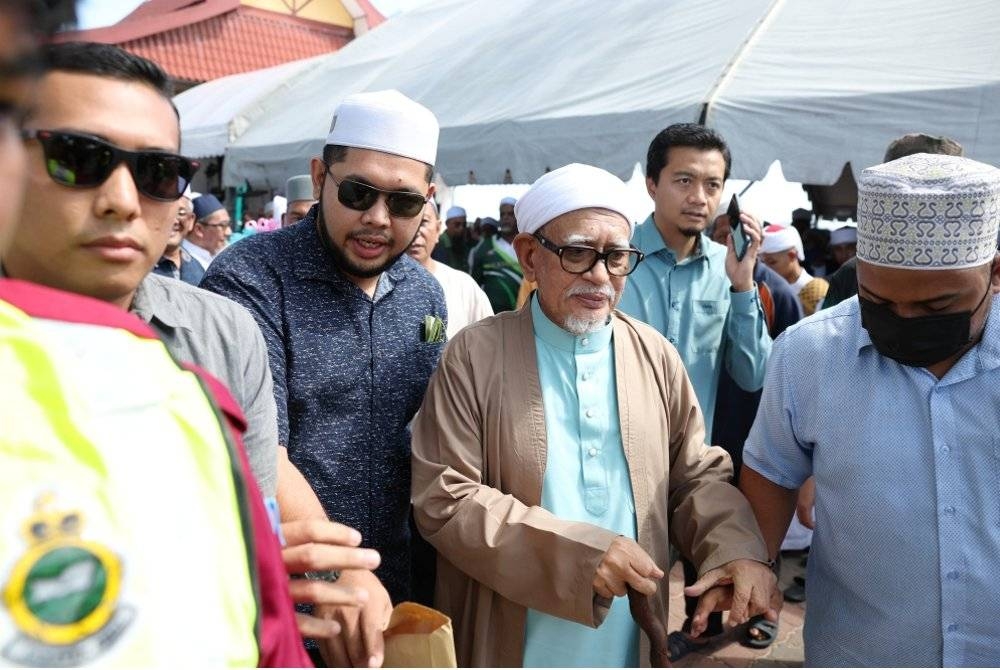 Abdul Hadi (tengah) dipimpin selepas menyampaikan kuliah duha di Pantai Kelulut di Marang pada Jumaat.