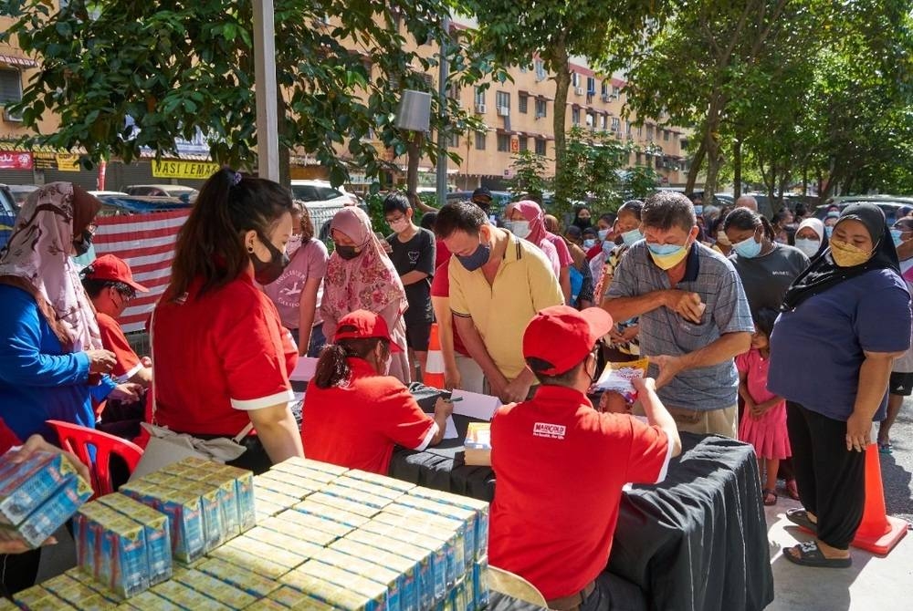 Orang ramai berkumpul untuk menerima susu UHT MARIGOLD percuma di PPR Sri Aman Jinjang, Kepong.