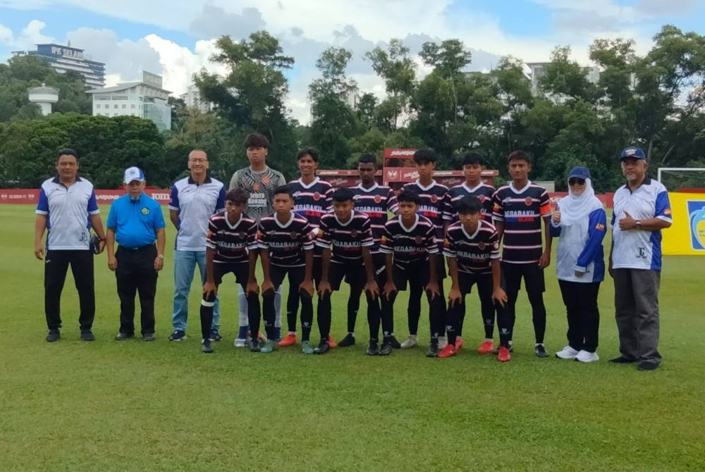 Ahmad Fariz (tiga dari kiri) bersama pasukan SMK Seksyen 7 sebelum perlawanan bermula di Padang Latihan Persatuan Bola Sepak Selangor (FAS) Shah Alam pada Sabtu.