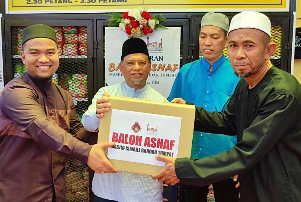 Rusydee (dua dari kiri) menunjukkan bantuan makanan asas menerusi Baloh Asnaf MIBT.