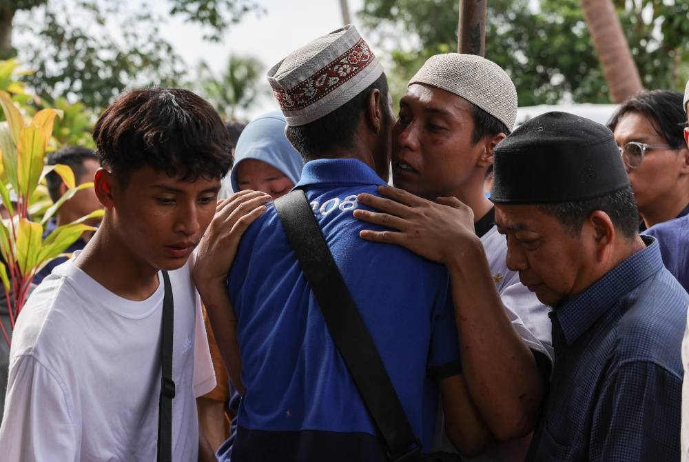 Redzuan (dua dari kanan) menerima ucapan takziah daripada saudara terdekat selepas selesai upacara pengkebumian isterinya, Nurul Nazihah Kamalul Arifin. - Foto Bernama