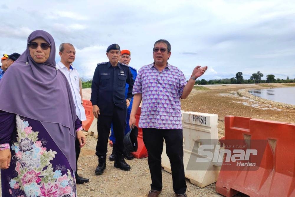 Abdul Latiff (kanan) melihat perkembangan Projek Tebatan Banjir JPS di Kampung Tersang, Rantau Panjang pada Ahad.