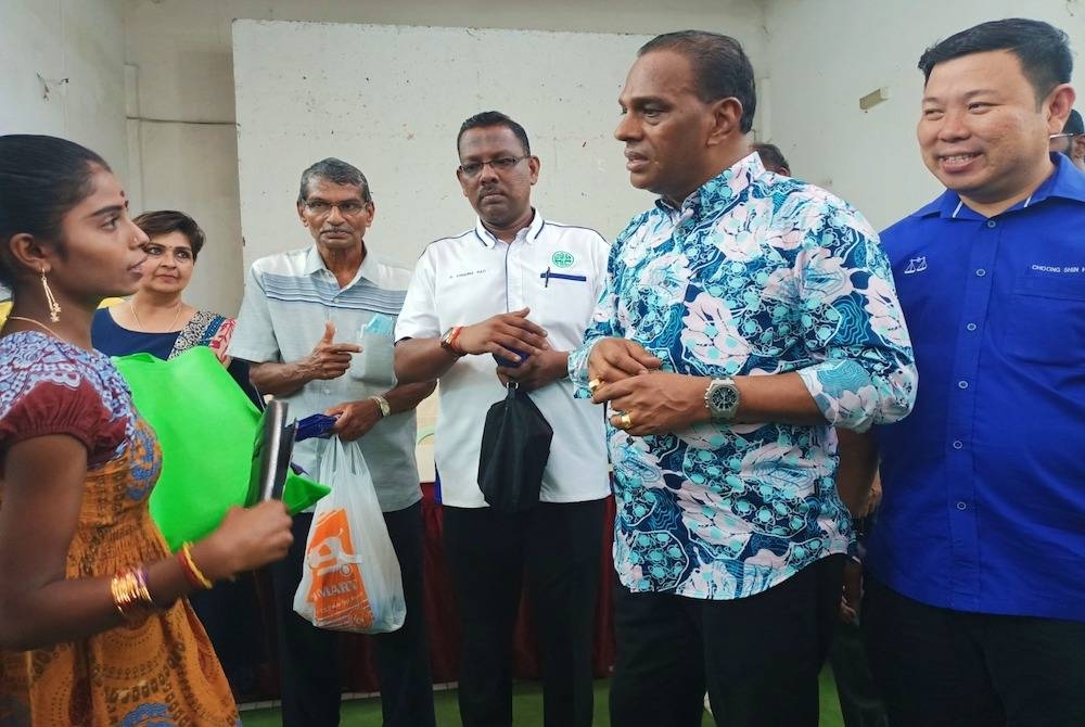 Saravanan (dua dari kanan) ketika menyampaikan sumbangan Deepavali kepada penduduk Parlimen Tapah pada Ahad.