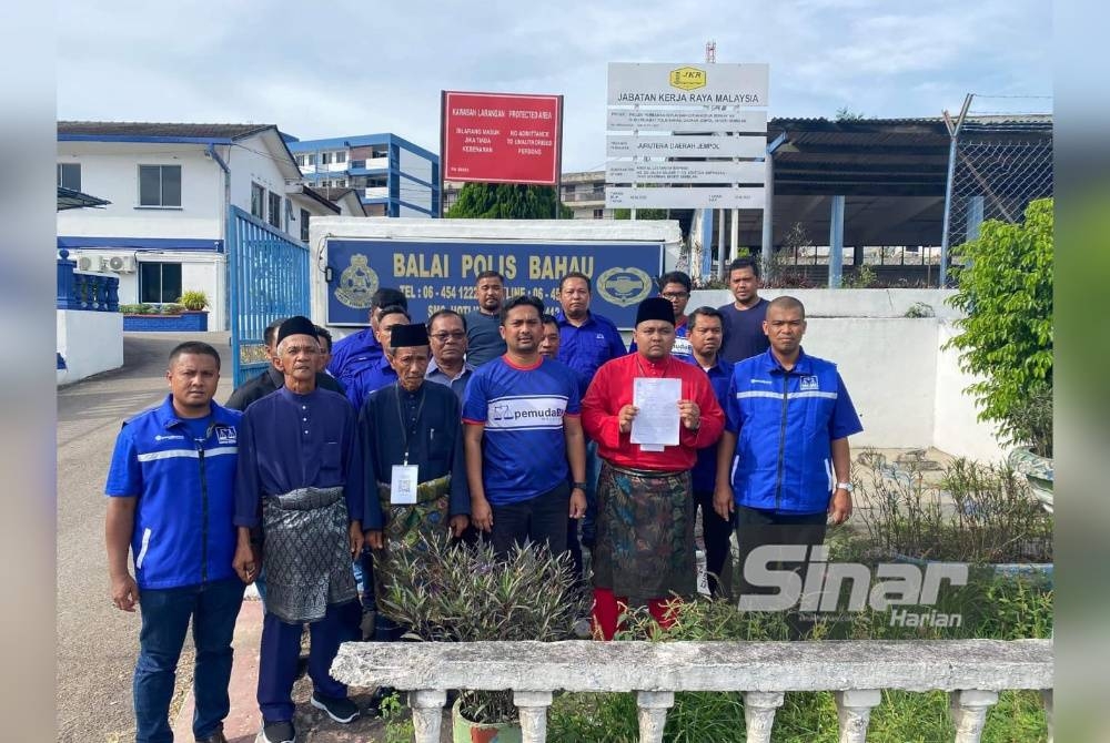 Mohd Zaidy (empat dari kiri) di hadapan Balai Polis Bahau selepas menemani ahli Pemuda UMNO Jempol yang membuat laporan polis berhubung kes berkenaan.