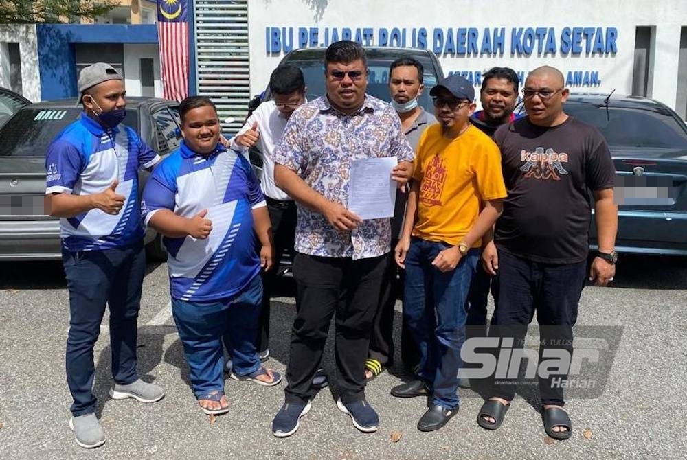 Syed Mohd Johan Rizal (tengah) menunjukkan laporan polis berkaitan isu penerokaan haram REE Bukit Enggang di hadapan IPD Kota Setar.