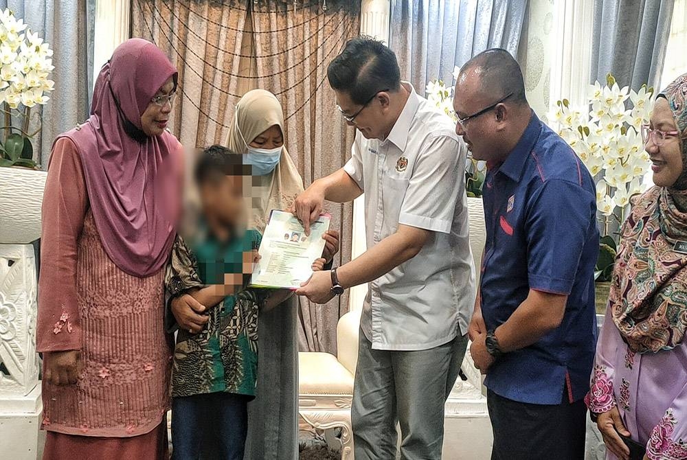 Ban Hong (empat dari kiri) dan Norazlee (lima dari kiri) ketika menyerahkan sijil warganegara kepada kanak-kanak itu pada Program Temu Seru JPN Melaka sempena Hari Pendaftaran Negara di Ayer Keroh di sini, pada Selasa.