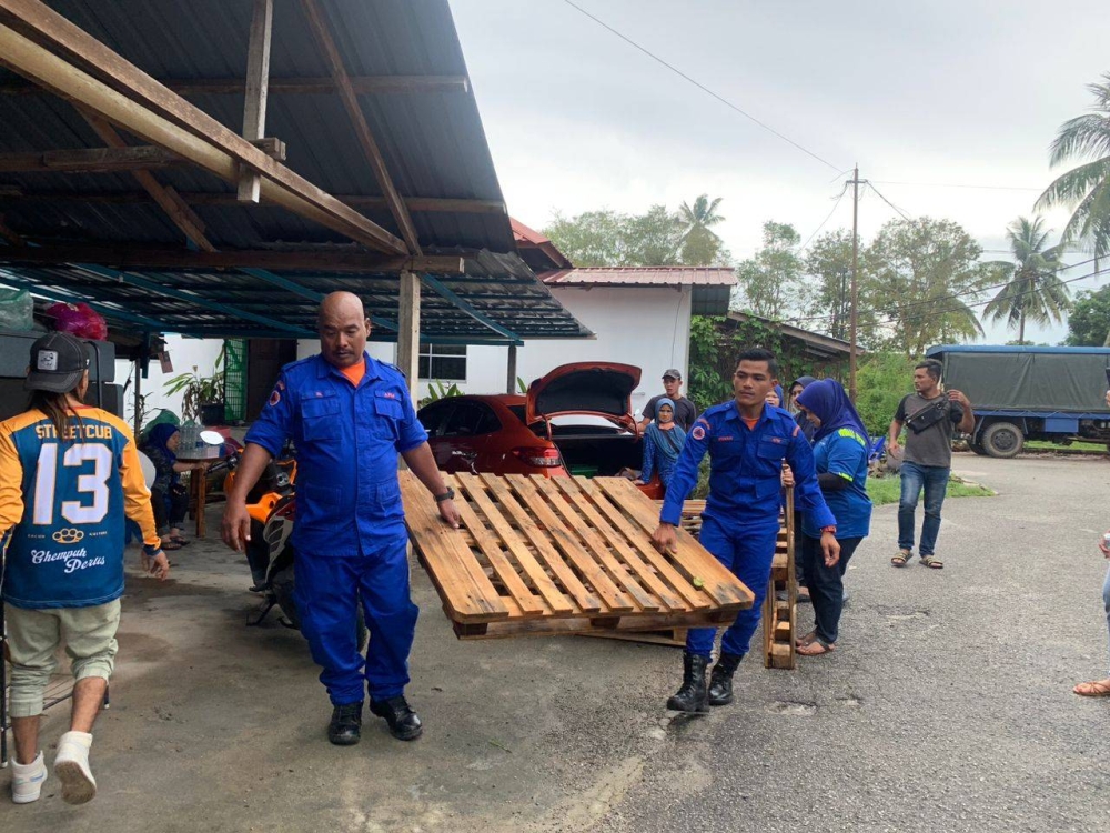 Anggota APM Langkawi melakukan kerja pembersihan pasca bencana banjir di Kampung Limbong Putra.