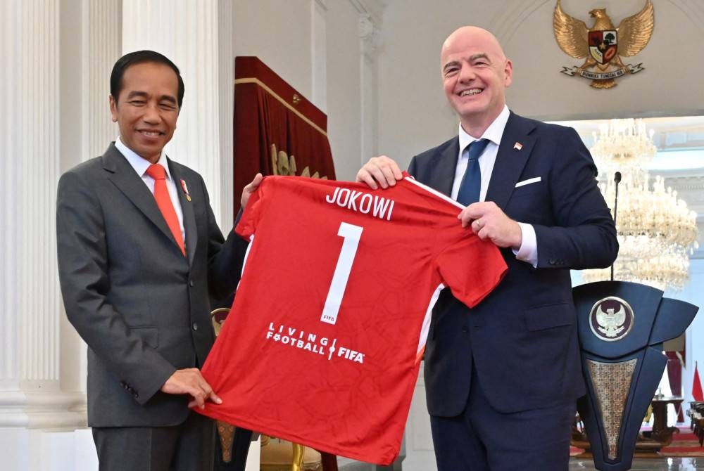 Infantino (kanan) menyampaikan jersi cenderahati Joko Widodo semasa kunjungan di Istana Presiden di Jakarta. - Foto AFP