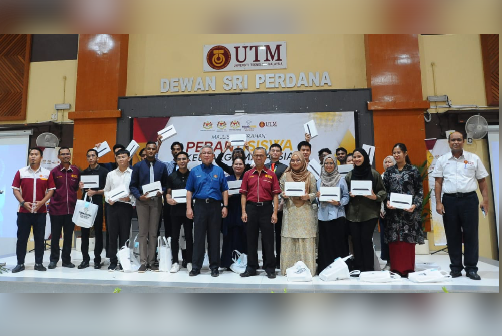 Dr Adham (tengah) bersama penuntut UTM ketika Majlis Agihan Peranti Mahasiswa Keluarga Malaysia di UTM Skudai, Johor Bahru pada Rabu.