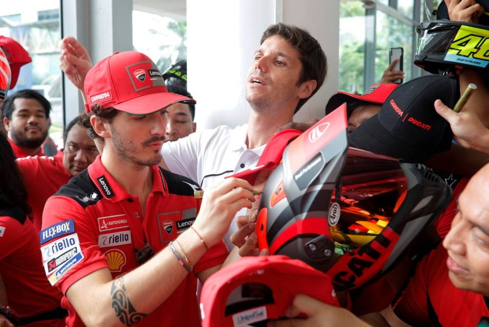 Bagnaia (kiri) melayan peminat ketika sesi temu ramah bersama peminat Ducati di Petaling Jaya pada Khamis. - Foto Bernama