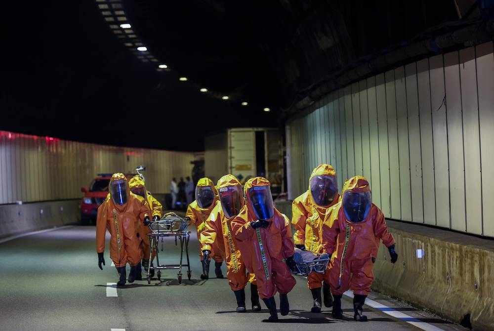 Pasukan Khas Bahan Kimia Berbahaya (Hazmat) Jabatan Bomba dan Penyelamat Malaysia (JBPM) membawa keluar &#039;mangsa&#039; pada Latihan Ex-Genting 2022 di Terowong Genting Sempah awal pagi Khamis. - Foto Bernama