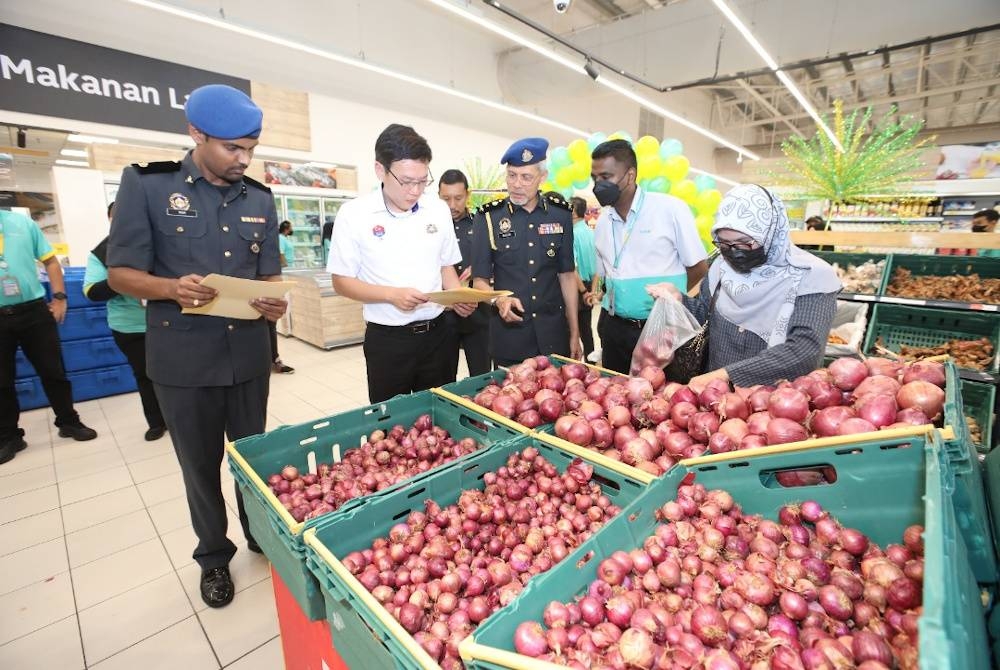 Tin Han (tengah) meninjau harga barangan kawalan sempena pelancaran Skim Harga Maksimum Musim Perayaan (SHMMP) Deepavali di Lotus Mutiara Rini, Johor Bahru pada malam Khamis