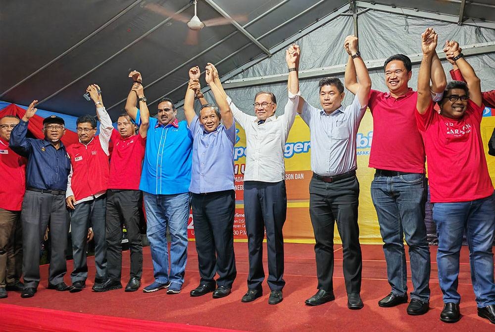 Anwar (empat dari kanan) mengumumkan Aminuddin (lima dari kanan) sebagai calon di kerusi Parlimen Port Dickson di Dataran Segar, Port Dickson pada Jumaat.