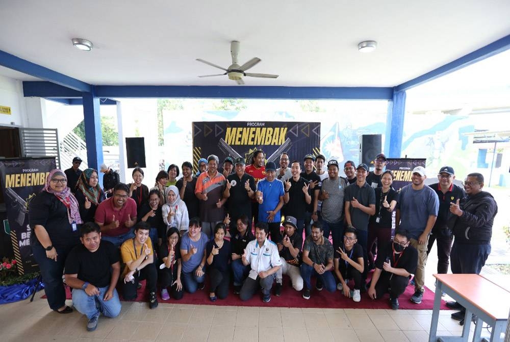 Kamaruddin (tengah) bergambar bersama petugas media yang menyertai pertandingan menembak anjuran SPRM.