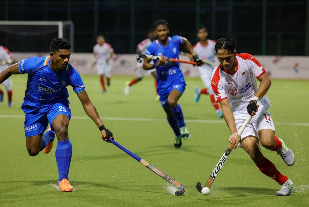 Pemain negara, Muhammad Danish Aiman (kanan) cuba melepasi pemain India, Lugan Cyril pada perlawanan Piala Sultan Johor di Stadium Hoki Taman Daya pada Sabtu.