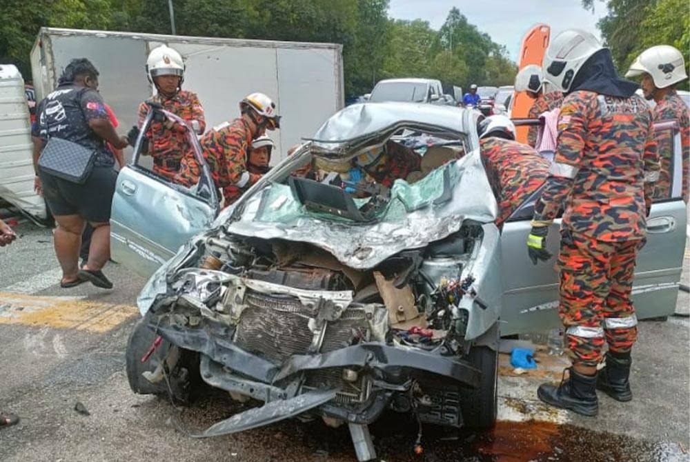 Anggota bomba mengeluarkan mangsa yang tersepit dalam kemalangan di Jalan Batu Pahat-Mersing di Kampung MIC, Kluang pada Ahad.