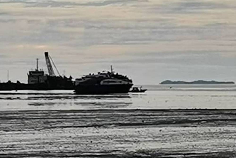 Feri tersangkut di beting lumpur dipercayai akibat air laut surut. - Foto JBPM