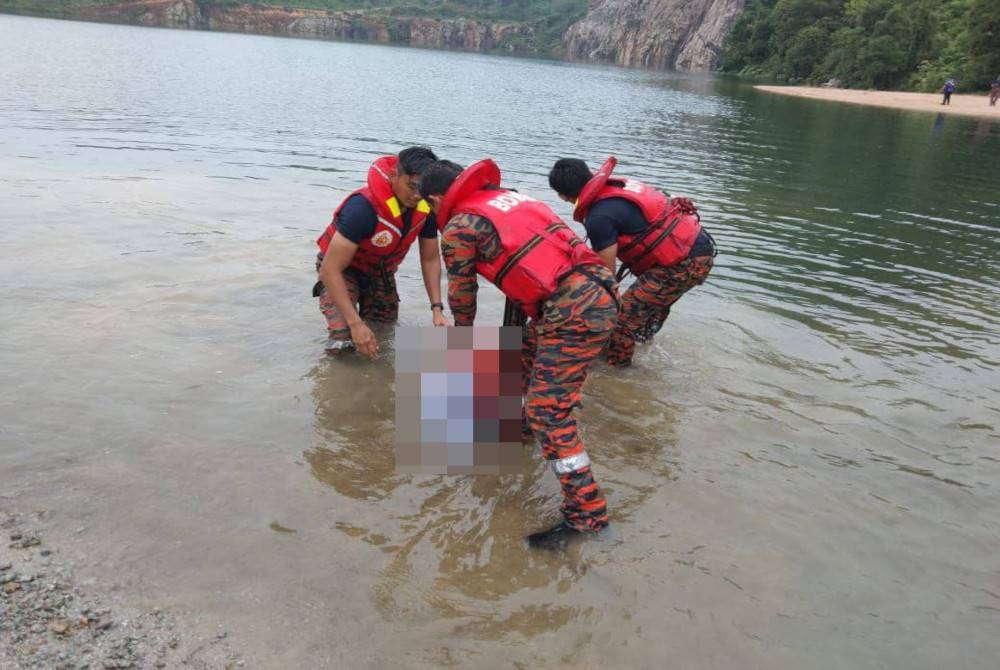 Anggota bomba mengangkat mayat mangsa yang lemas di Tasik Tiga Beradik pada Isnin.