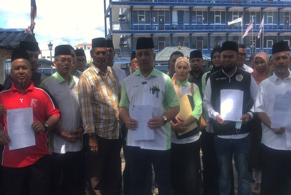 Tengku Abdul Manan (tengah) menunjukkan laporan polis yang telah dibuat terhadap Tengku Zulpuri di IPD Kuantan di sini pada Rabu.