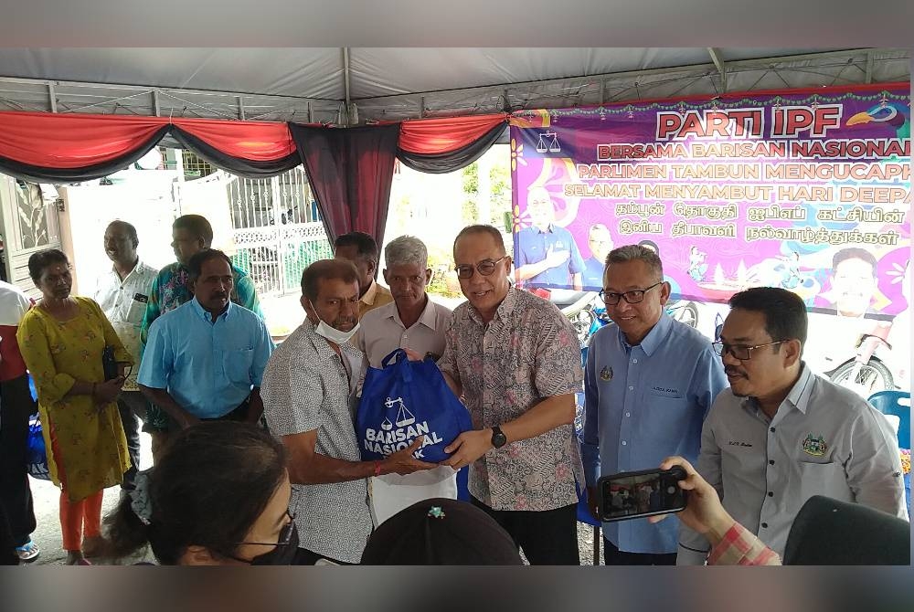 Aminuddin (tiga dari kanan) menyampaikan sumbangan kepada penduduk ketika hadir ke Majlis Rumah Terbuka Deepavali Parti IPF Bersama BN Tambun di No 144, Hala Klebang Restu 1, Medan Klebang Restu, Chemor, di sini pada Selasa.