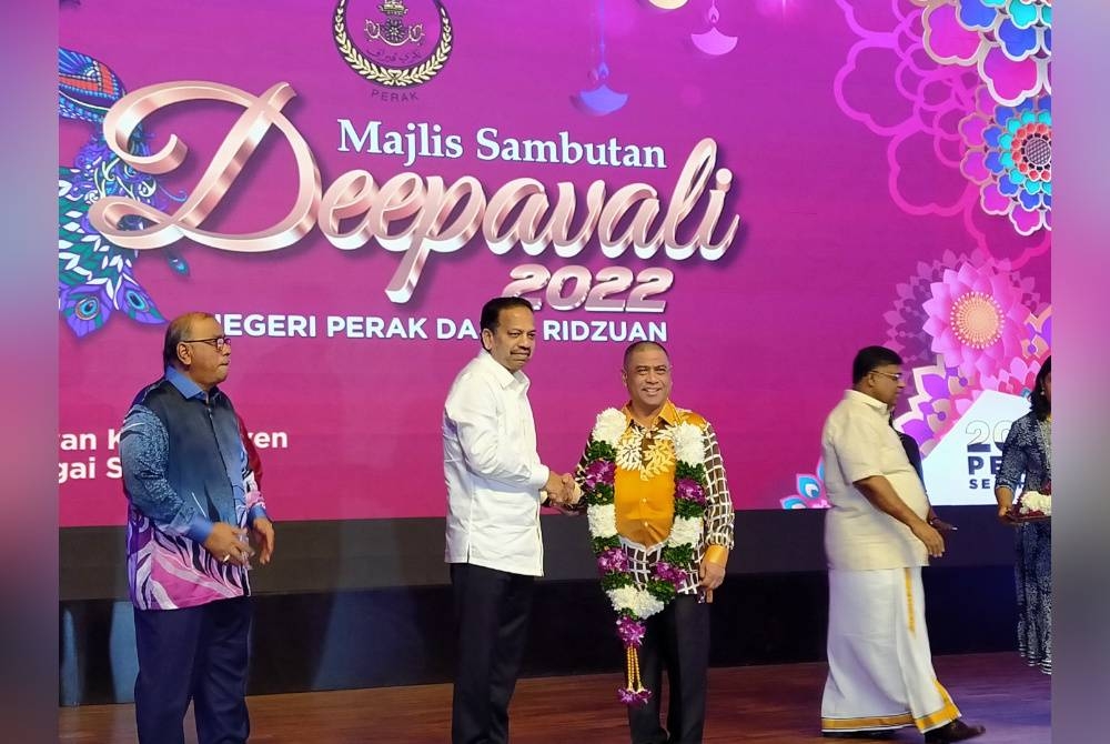 Vickneswaran (kiri) bersalaman dengan Saarani selepas mengalungkan bunga malai selepas menghadiri Majlis Sambutan Deepavali Tahun 2022 Kerajaan Negeri Perak di Dewan Konvensyen Tun Samy Vellu pada Selasa.