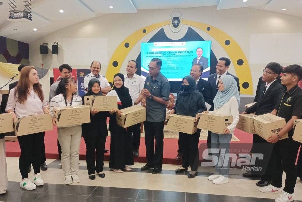 Rosol (tengah) berbual dengan penerima kotak sumbangan barang keperluan pada Majlis Ramah Mesra Program Food Bank Malaysia bersama mahasiswa.