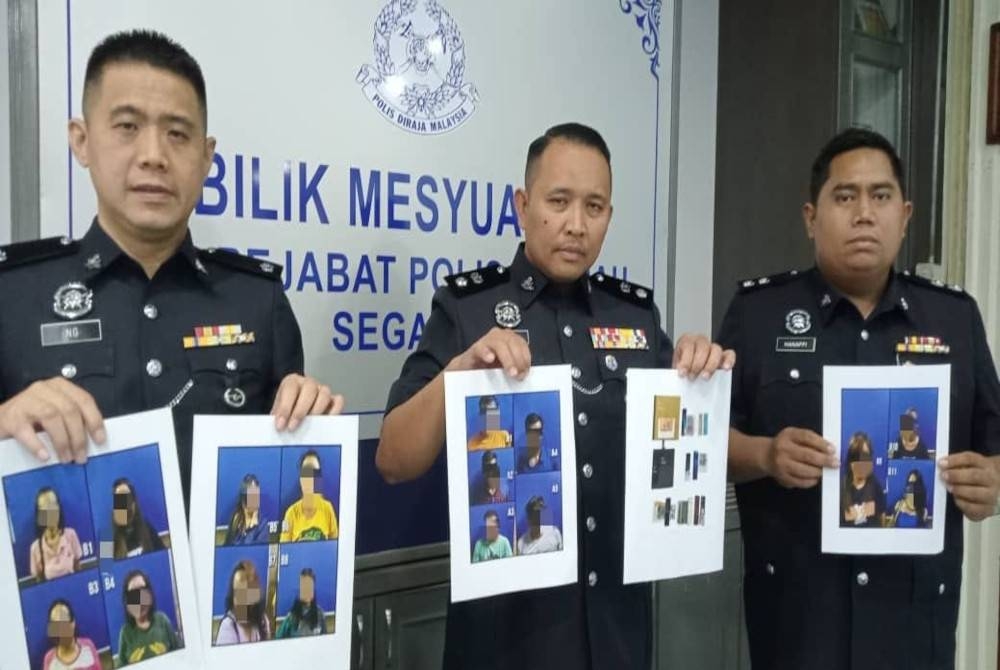 Ahmad Zamry (tengah) menunjukkan gambar pelacur tempatan dan lelaki warga asing yang ditahan dalam Op Noda selepas sidang akhbar di IPD Segamat, Segamat pada Rabu.