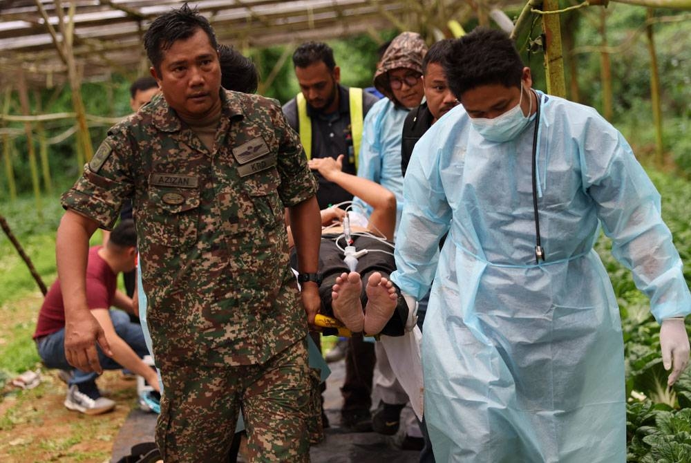 Mangsa pertama daripada lima petugas perubatan termasuk seorang doktor yang mengalami kecederaan dibawa keluar dari lokasi selepas helikopter dinaiki terhempas di kawasan Brinchang tengah hari Rabu. - Foto Bernama