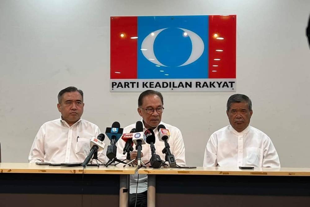 Anwar (tengah) pada sidang akhbar di Petaling Jaya pada Sabtu ketika mengumumkan tiga negeri PH tidak membubarkan DUN masing-masing.