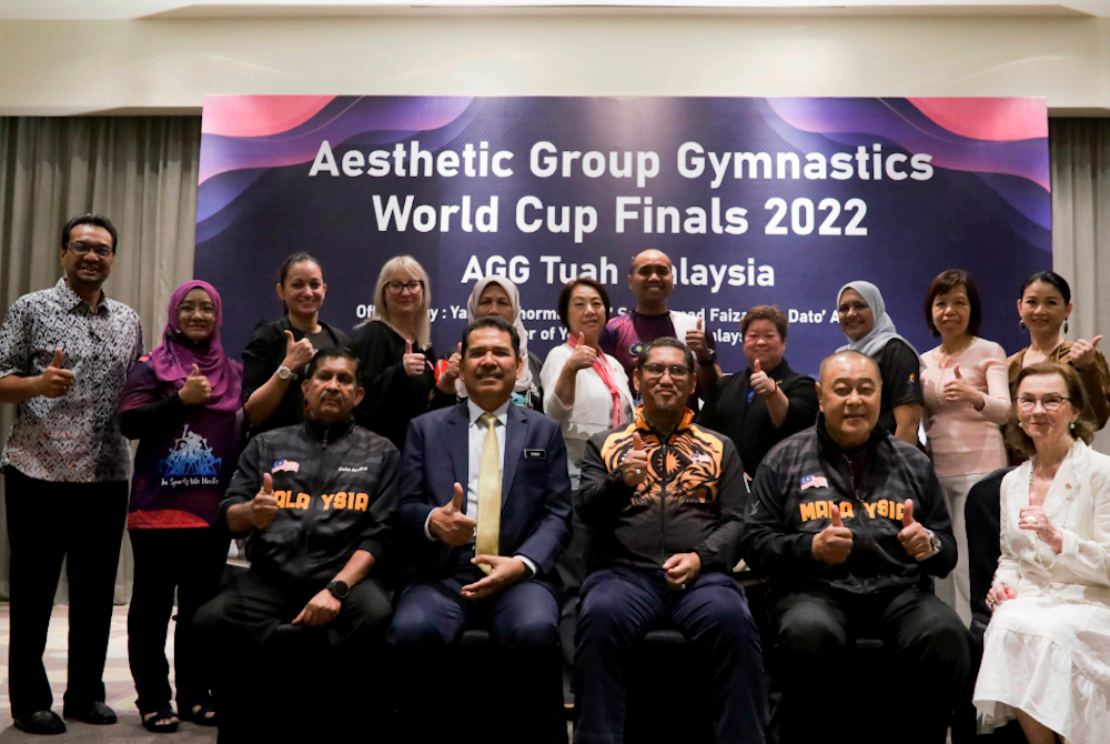 Ahmad Faizal (duduk, tengah) bersama anggota dan pegawai AGG selepas merasmikan Piala Dunia 2022 AGG Tuah Malaysia.