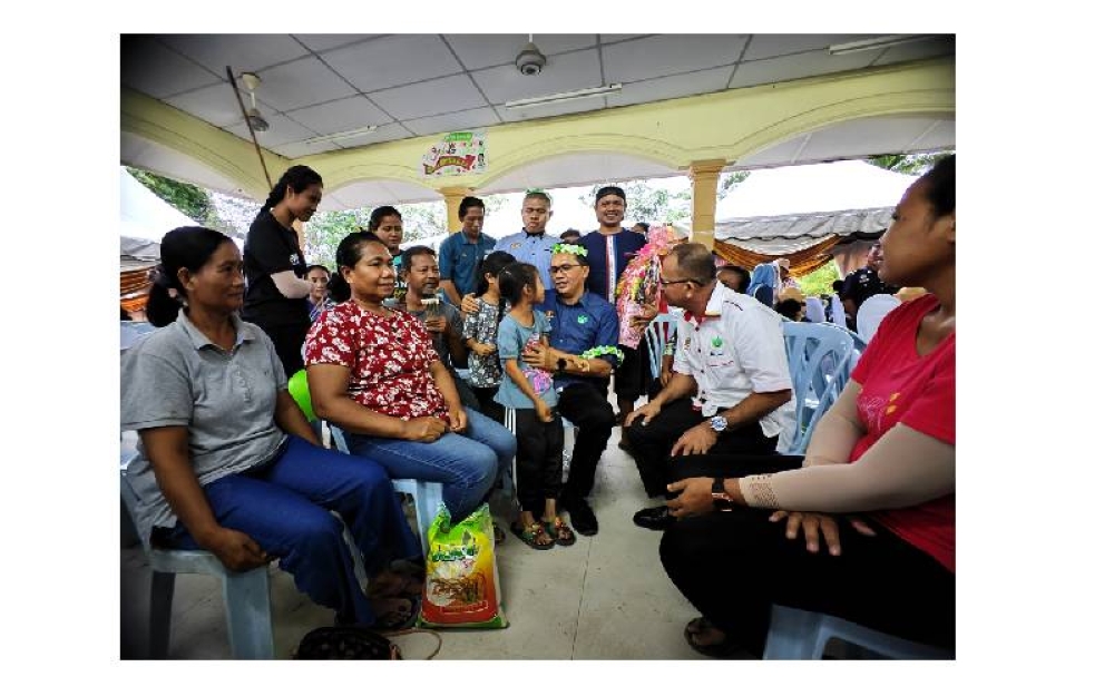 Mohd Salim (duduk, tengah) beramah mesra dengan masyarakat Orang Asli Kampung Panchor ketika hadir program Pekebun Kecil Makmur RISDA Bersama Jabatan Hal Ehwal Orang Asli dan Jelajah Kasih Keluarga Malaysia.