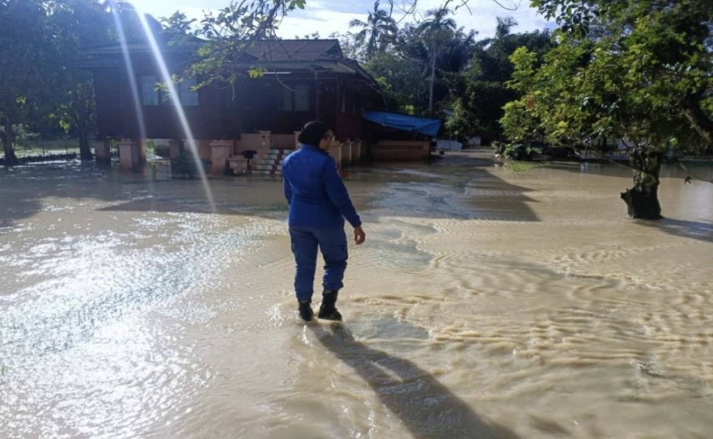 Hujan lebat berterusan sejak kira-kira 3.30 petang tadi yang menyebabkan limpahan air Sungai Tampin. Foto Bernama. 