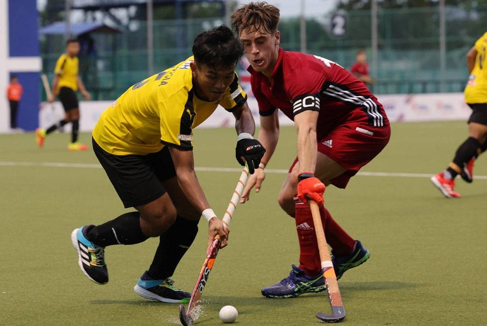 Pemain negara, Muhammad Addy Jazmi Jamlus dicabar pemain Great Britain, Fred Newbold pada aksi Piala Sultan Johor di Stadium Hoki Taman Daya pada Rabu.