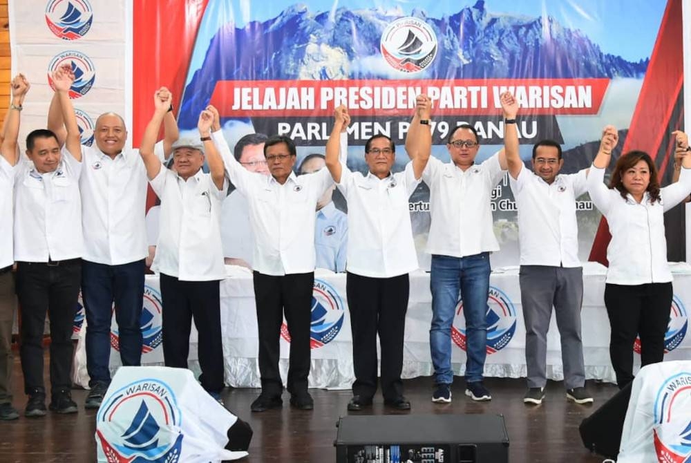 Mohd Shafie (empat dari kiri) bergandingan tangan bersama Marcos (lima dari kiri) sebagai calon kerusi Parlimen Ranau, sempena pelancaran jentera Warisan Bahagian Ranau, di Dewan Pertubuhan Chon Chun Kung, Ranau pada Sabtu.