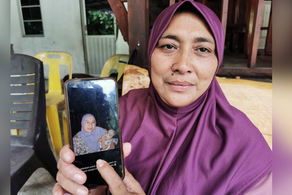 Sharifah Suzi Suriani menunjukkan gambar arwah anaknya, Allahyarham Fatin Hazlin Dahlia bersama Sayyid Uwais Al-Qarni ketika ditemui di kediaman di Kampung Batu Hampar, Manir, di Kuala Terengganu, pada Sabtu.