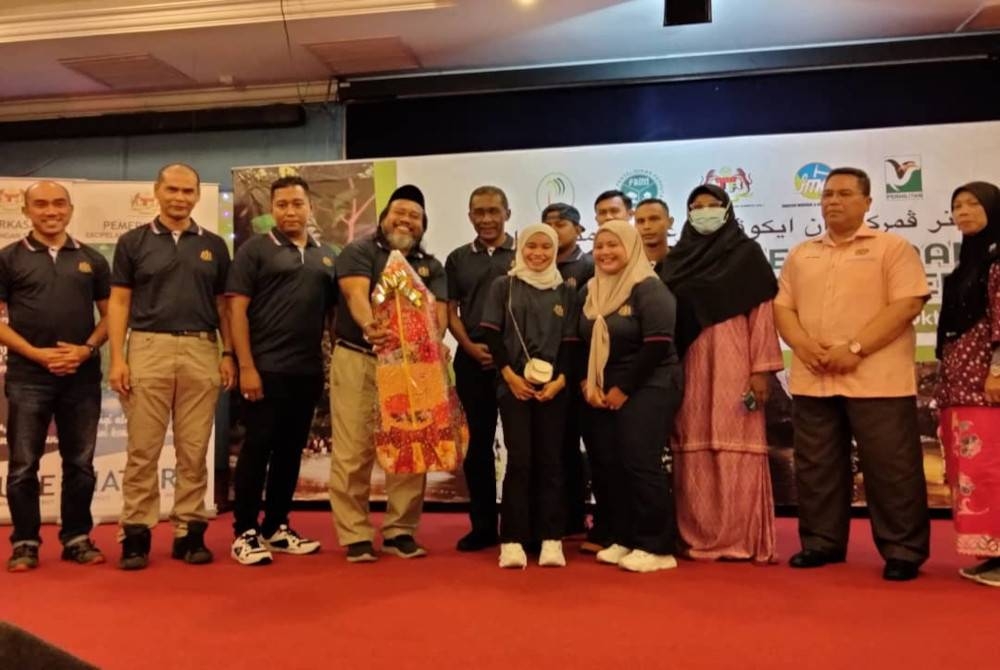 Takiyuddin menyampaikan hadiah kepada pemenang Program Seminar Pemerkasaan Ekopelancongan Sumber Asli di Pantai Cahaya Bulan pada Jumaat.