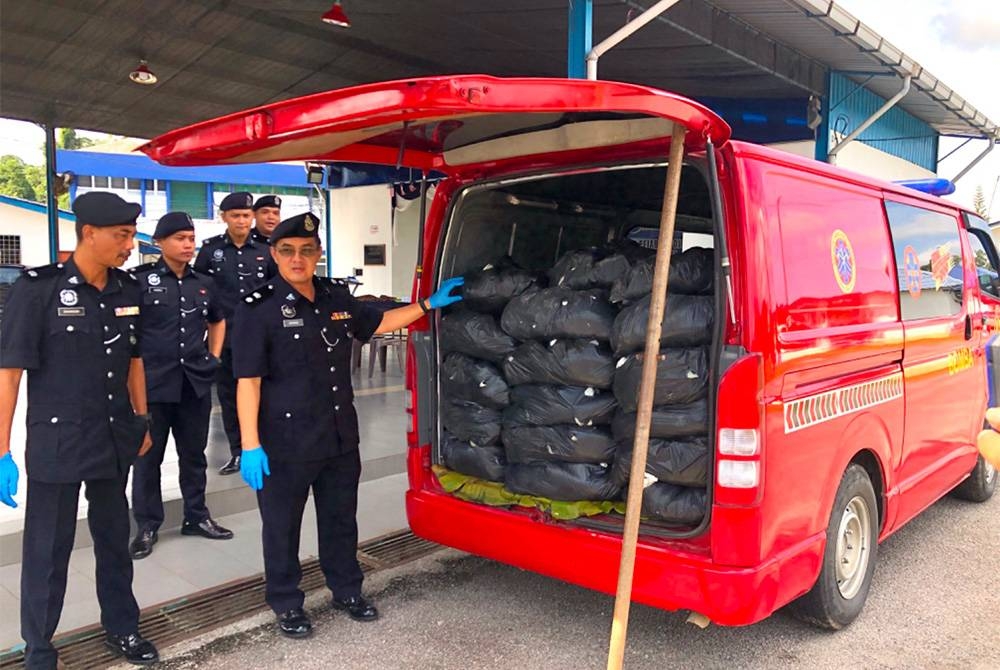 Ahmad (kanan) menunjukkan bungkusan plastik hitam mengandungi daun ketum.