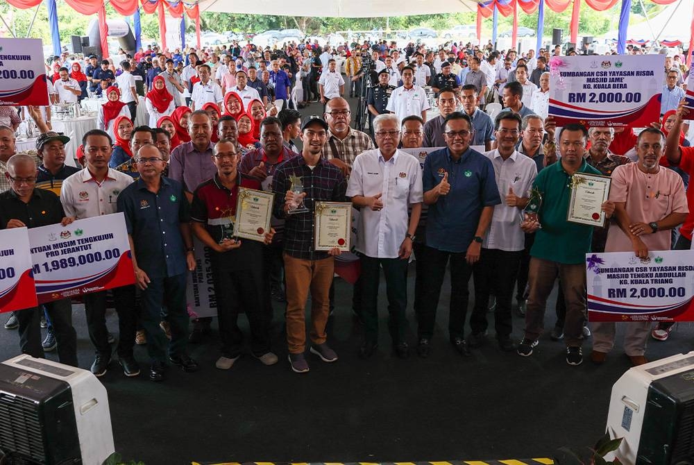 Ismail Sabri Yaakob bergambar bersama sebahagian wakil penerima sumbangan, penerima anugerah dan hadirin yang hadir pada Program Pekebun Kecil Makmur di Kampung Batu Papan hari ini. Foto Bernama