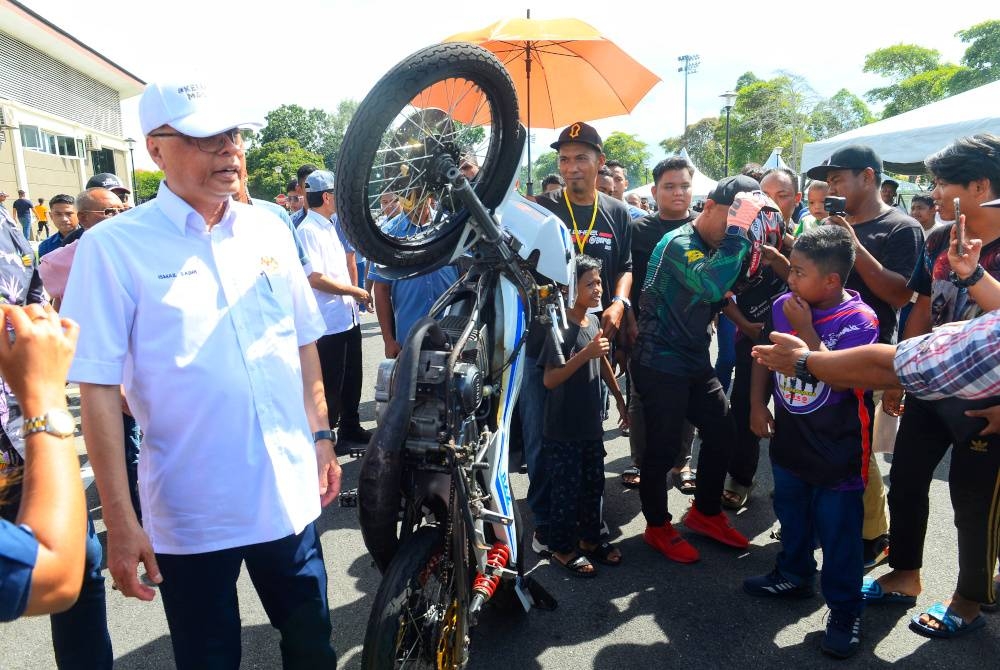 Ismail Sabri (kiri) melihat motosikal yang dipamerkan ketika Program Moh Wei 2 Waheel di Dataran Dewan Konvensyen Bera pada Ahad.