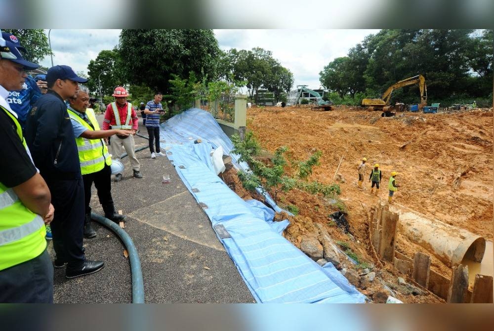 Onn Hafiz diberi taklimat ringkas semasa melawat kawasan paip pecah di Bandar Seri Alam, Masai, Johor Bahru, pada Isnin.