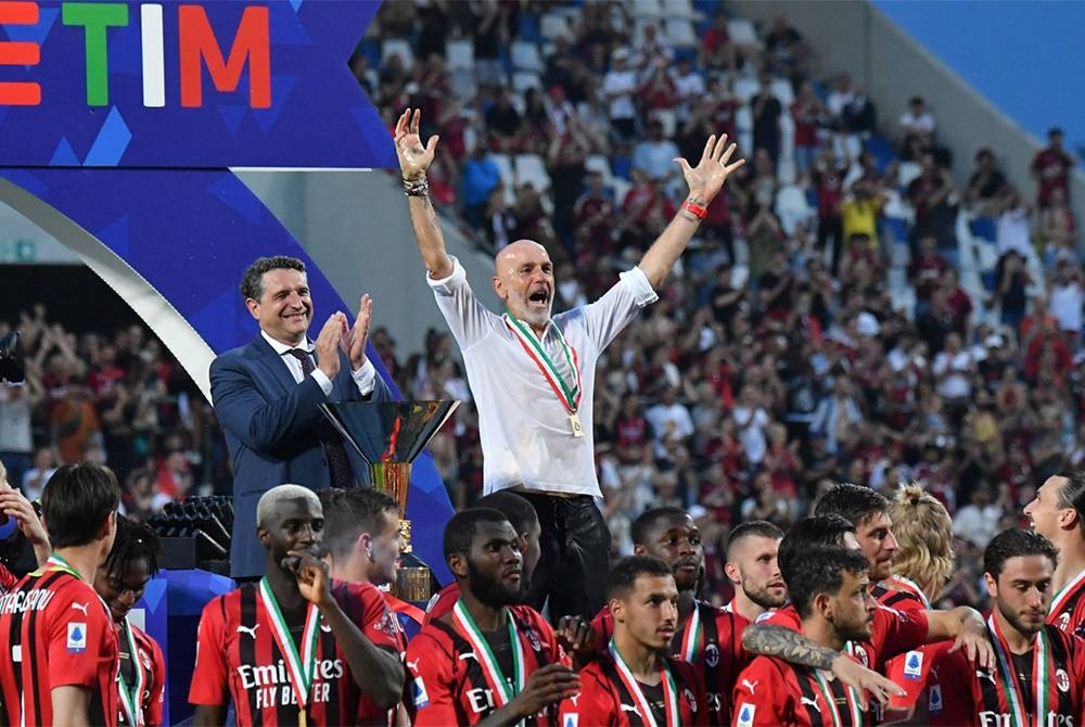 Pioli (tengah) meraikan kejayaan menamatkan penantian 11 tahun Scudetto bersama pemain Milan pada musim lepas.