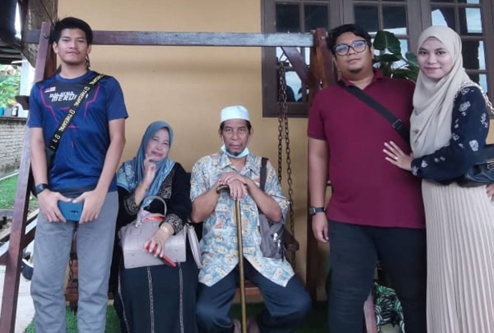 Muhammad Hafiz (kiri) bersama arwah bapanya, Mokhtar (tengah) ketika tiba di sebuah rumah inap di Ajil, Hulu Terengganu pada hari pertama sampai di Terengganu, Ahad lalu. 