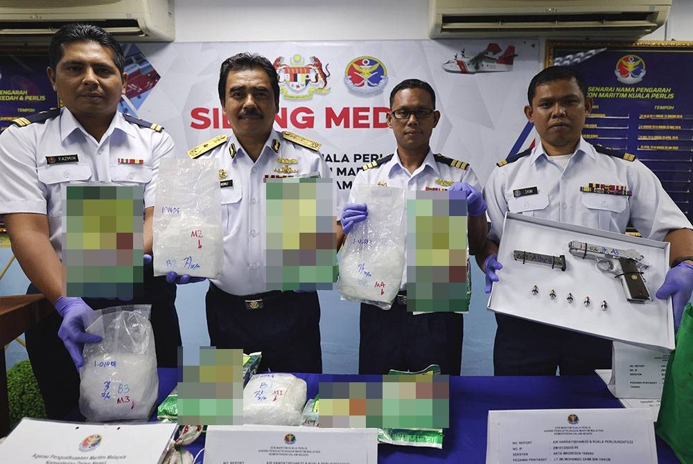 Pengarah Maritim Malaysia Negeri Kedah dan Perlis Laksamana Pertama Maritim Romli Mustafa (dua, kiri) menunjukkan barang rampasan ketika sidang media mengenai tangkapan dadah, senjata api dan dua suspek hari ini. - Foto Bernama